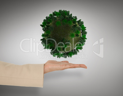 Composite image of female hand presenting green sphere