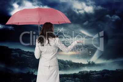 Composite image of businesswoman holding umbrella