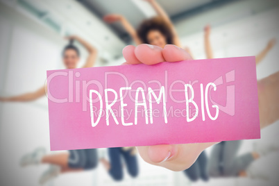 Woman holding pink card saying dream big