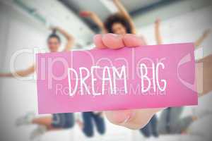 Woman holding pink card saying dream big