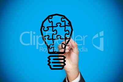 Composite image of businessman drawing light bulb