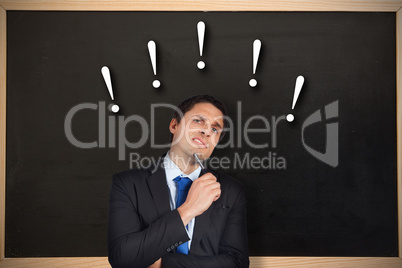 Composite image of thinking businessman holding pen