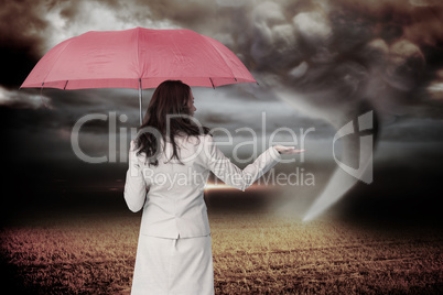 Composite image of businesswoman holding umbrella