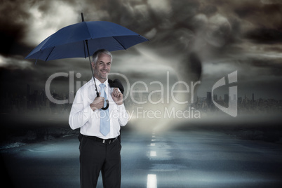 Composite image of happy businessman holding umbrella