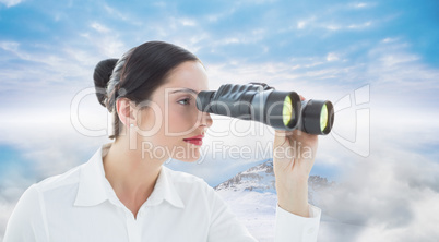 Composite image of business woman looking through binoculars