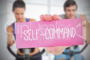 Woman holding pink card saying self command