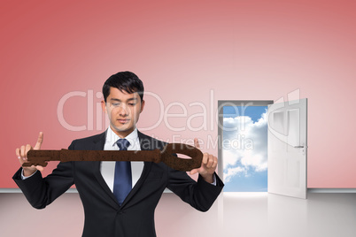 Composite image of unsmiling businessman carrying large key