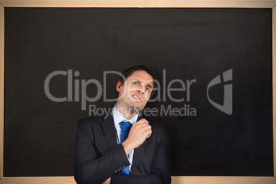 Composite image of thinking businessman holding pen