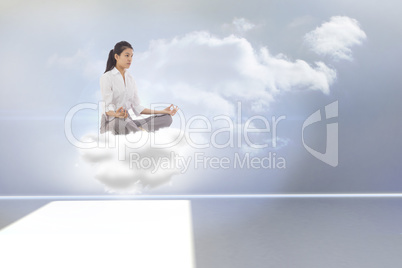 Composite image of businesswoman sitting in lotus pose