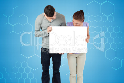 Composite image of attractive young couple showing card