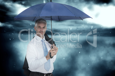 Composite image of businessman holding blue umbrella