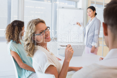 Casual businesswoman smiling at colleague during meeting