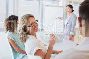 Casual businesswoman smiling at colleague during meeting