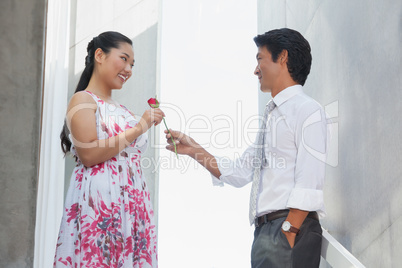 Man offering a red rose to girlfriend