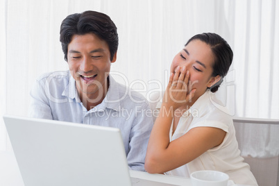 Happy couple using laptop together