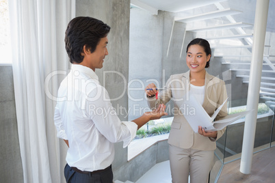 Estate agent giving house key to buyer