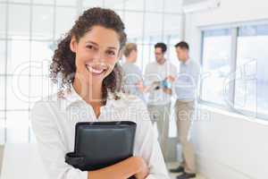 Casual businesswoman smiling at camera holding diary