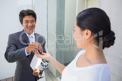 Estate agent giving house key to buyer