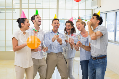 Casual business team celebrating with champagne and party popper