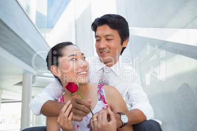 Man offering a red rose to girlfriend