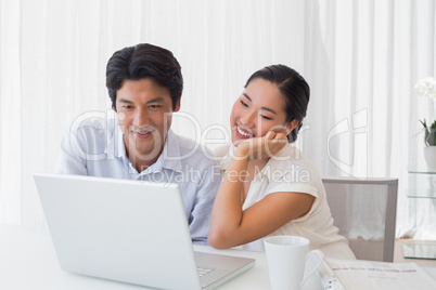 Happy couple using laptop together