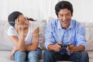 Man ignoring his girlfriend playing video games