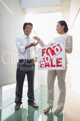 Estate agent giving keys to new home owner