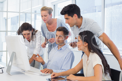 Casual businessman showing colleagues something on computer