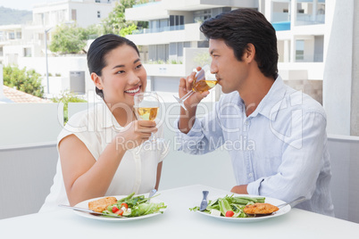 Happy couple having a meal together with white wine