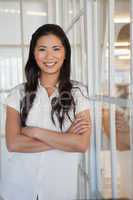 Casual businesswoman smiling at camera with arms crossed