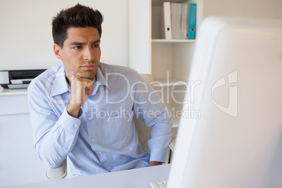 Casual businessman focusing at his desk