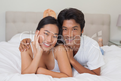 Happy couple lying on bed