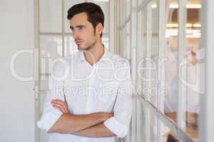 Casual upset businessman leaning against window