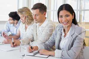 Casual businesswoman smiling at camera during meeting