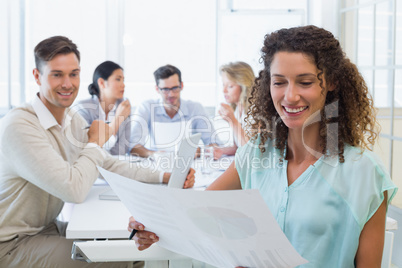 Casual businesswoman reading document during meeting