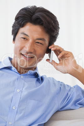 Happy man sitting on couch on the phone