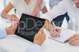 Casual businessman using his tablet during meeting