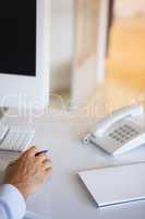 Casual businessman at desk with notepad and telephone