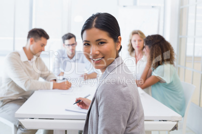 Casual businesswoman smiling at camera during meeting