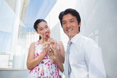 Man offering a red rose to girlfriend