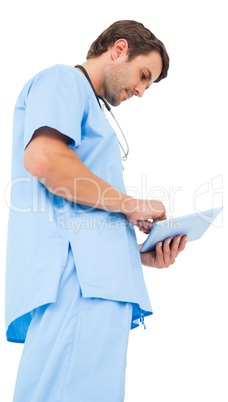 Handsome surgeon in blue scrubs using tablet pc