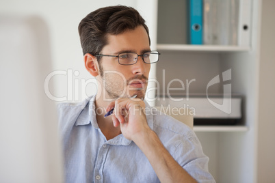 Casual businessman thinking at his desk