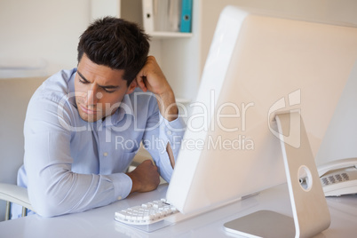 Casual businessman slumped at his desk