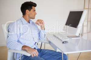 Casual businessman looking at computer screen