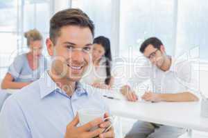 Casual businessman smiling at camera during meeting