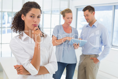 Casual businesswoman looking at camera with hand on chin