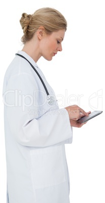 Blonde doctor in lab coat using tablet pc