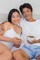 Happy couple having breakfast in bed