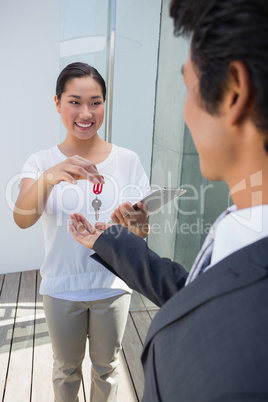 Estate agent giving house key to buyer