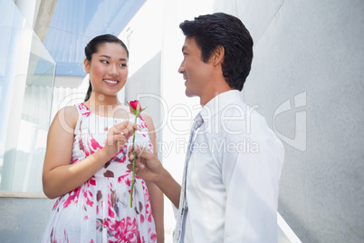 Man offering a red rose to girlfriend